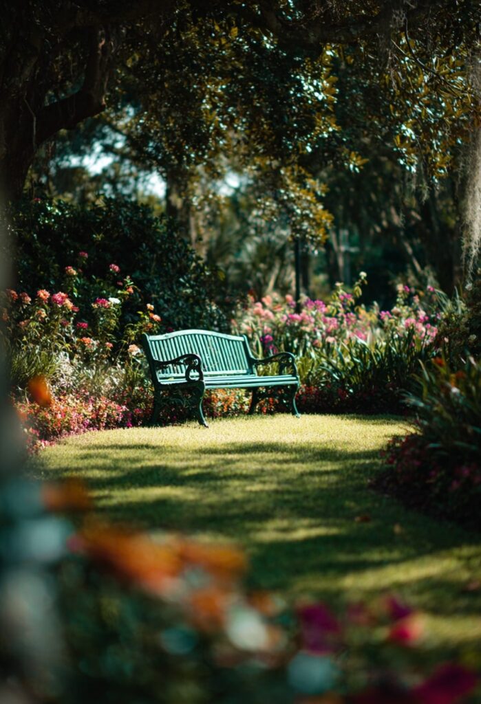 10. Classic Green Metal Bench in a Floral Garden